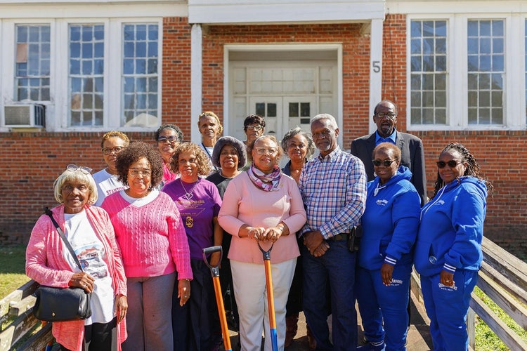 Group of 15 people, including Dr. Clarice White, project champion and Stanton School alumna standing on the ramp outside the Stanton Community Center.