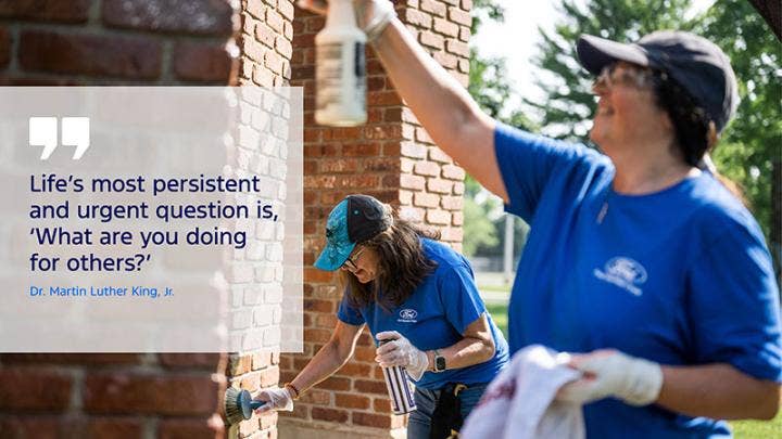 Two people cleaning the front of a house and text on the left