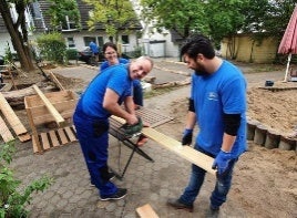 Two people sawing wood