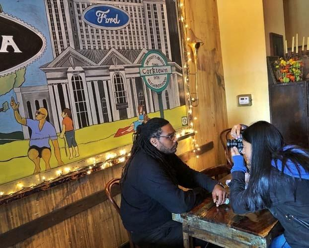 two people in front of a ford mural