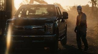 Silhouette view of a Ford truck and it's driver in a smoky sun scene