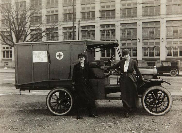 A couple of Red Cross workers stand beside a Nashville Chapter Ford Military Ambulance.