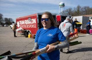 Ford volunteer in front of the Team Rubicon truck carrying shovels