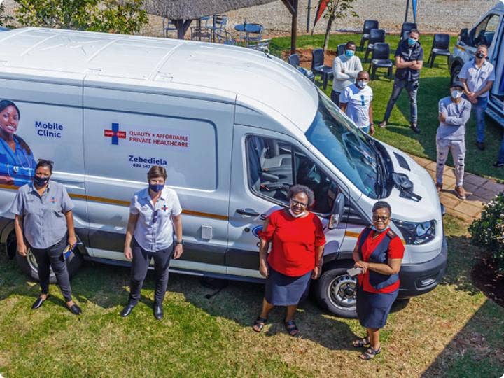 A group of volunteers next to a mobile healthcare center