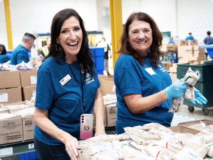 Two volunteers for Feeding America working with donations