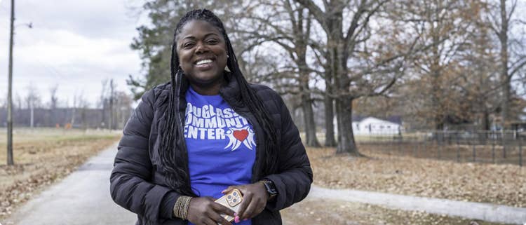 A smiling woman standing on an open road