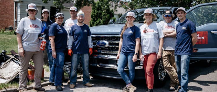 A group of people in front of a truck