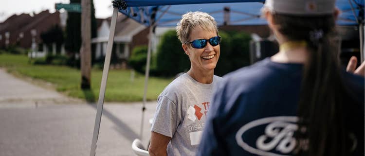 A person with a gray t-shirt smiling to another