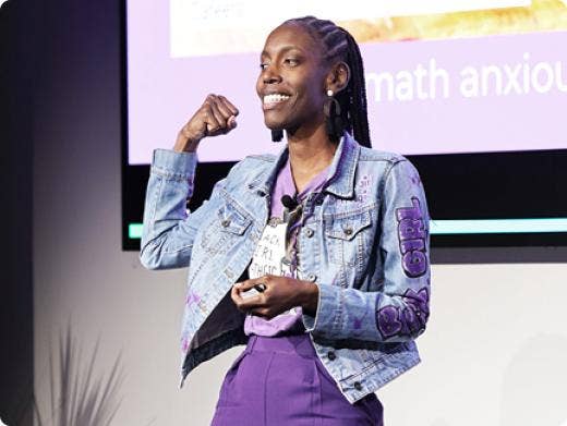 A woman giving a speech in front of a screen